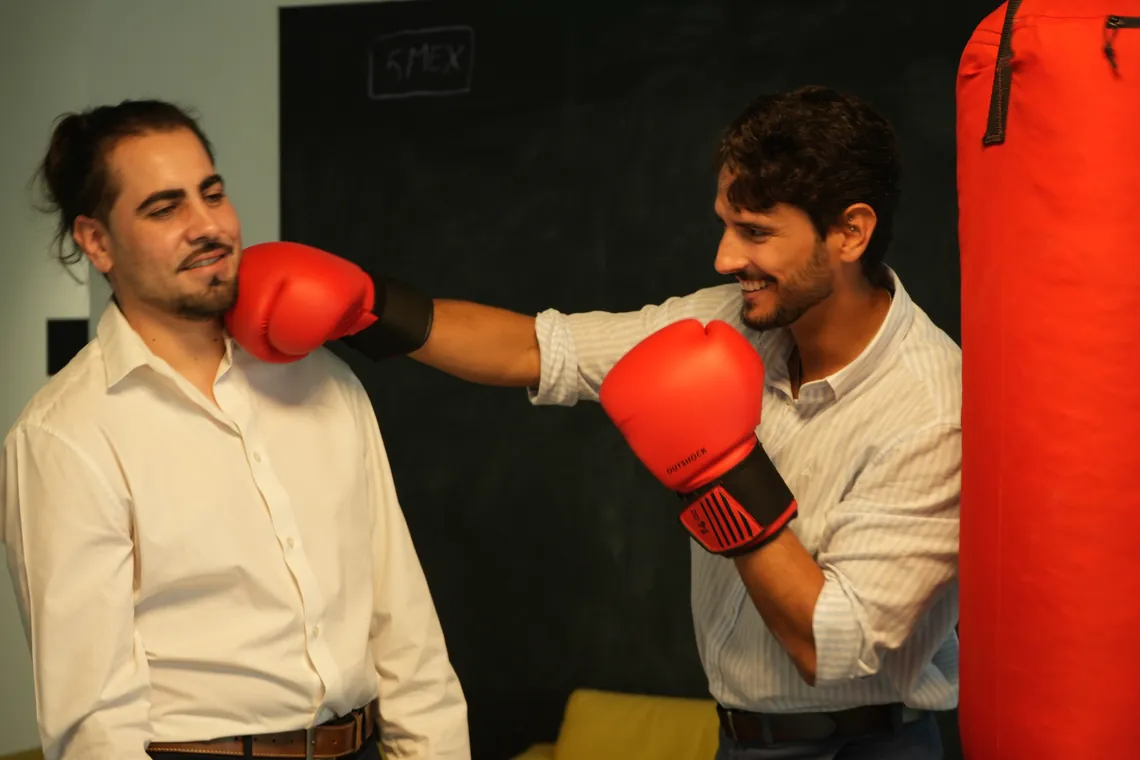 Two team members joking around with boxing gloves at the office