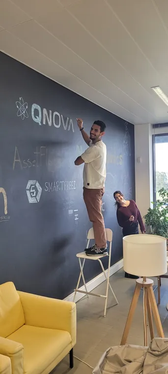 A team member drawing the company logo in chalk on the office wall