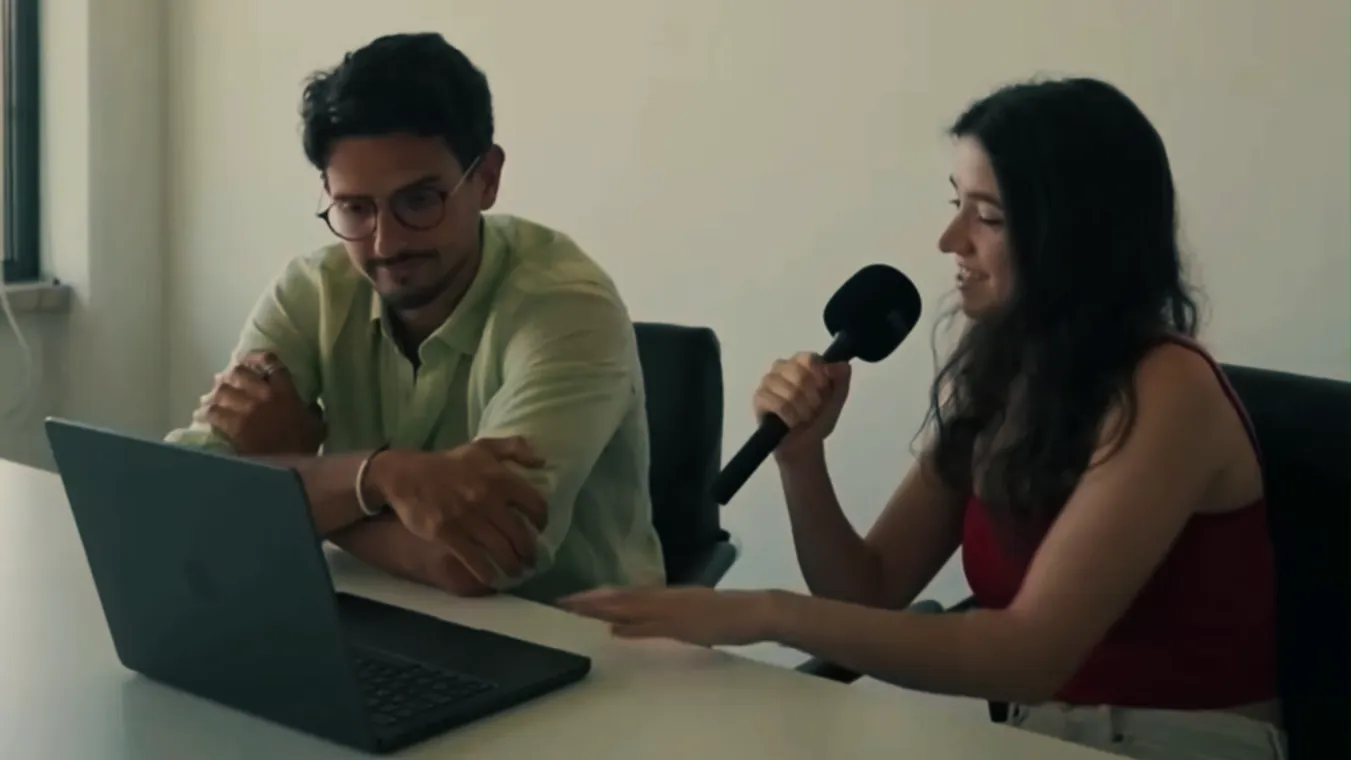 Two team members recording an interview at a desk