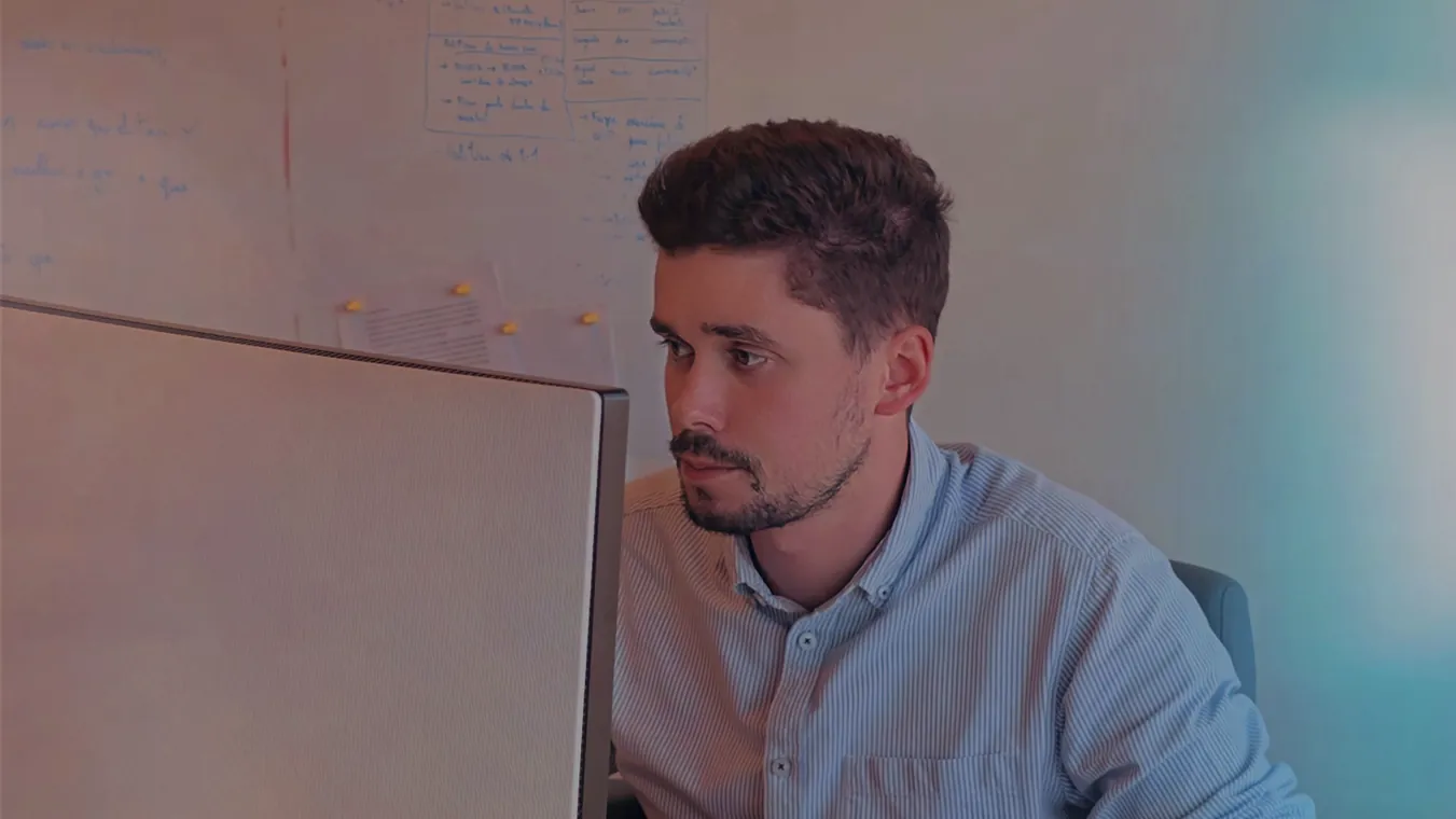 A team member thinking in front of a whiteboard